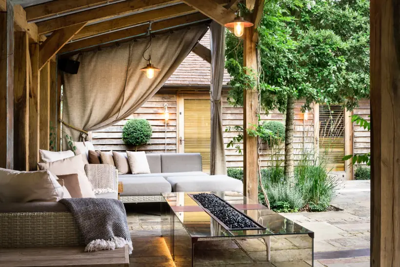 pergola housing an outdoor living space with outdoor seating and a fireplace